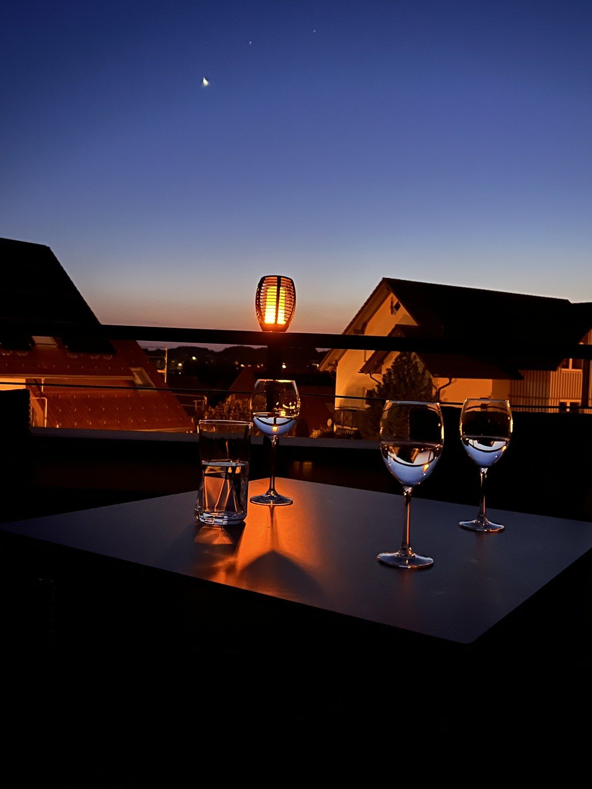 Dachterrasse am Abend mit Laterne und Weingläsern