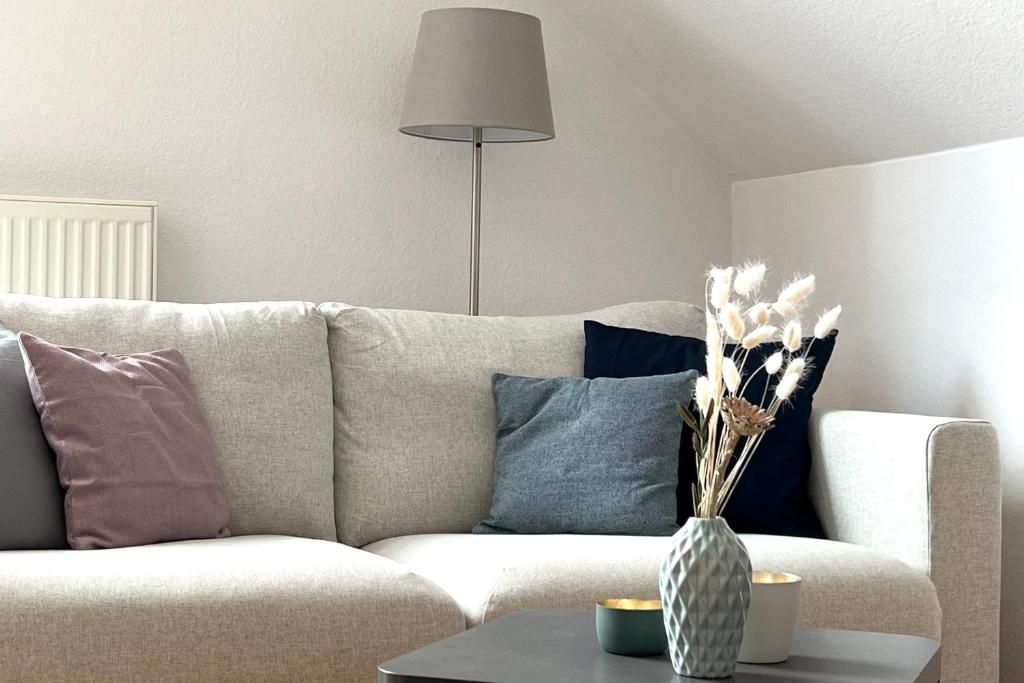 Helles Sofa mit Kissen und Stehlampe